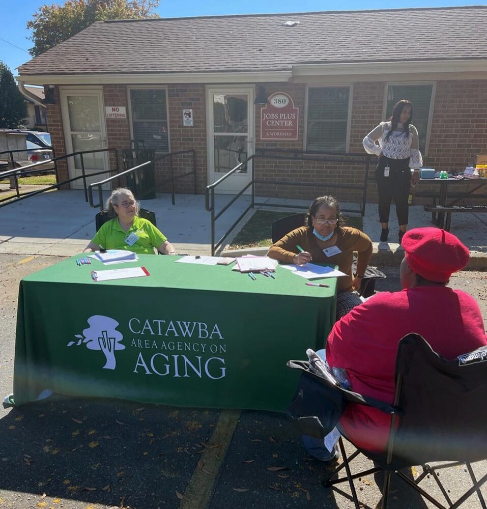 Two RHHA employees sit behind a table and asses a resident that is seated across from them. 