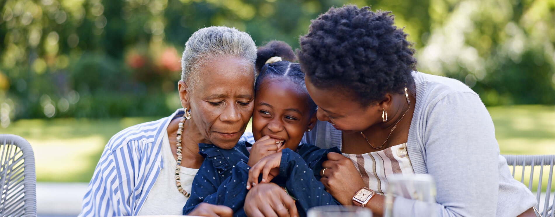 Grandmother, daughter, and grandchild outside.