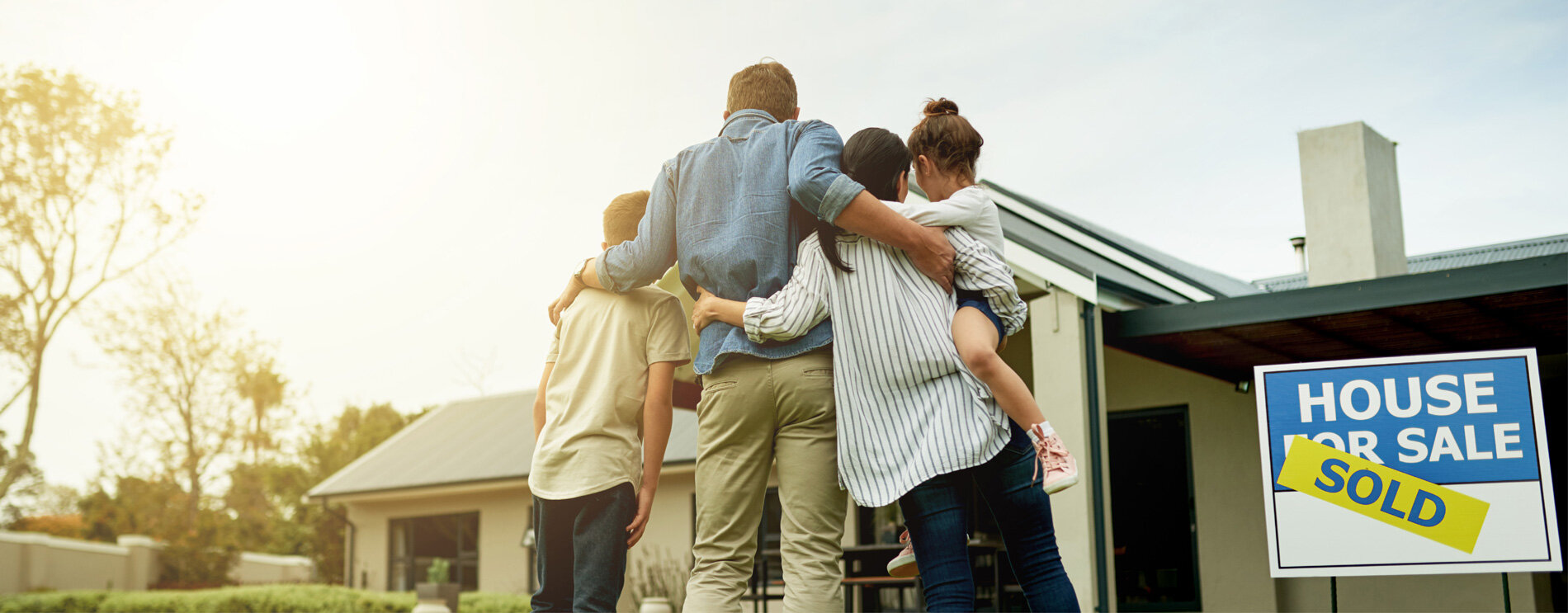 A family embracing after purchasing a home.