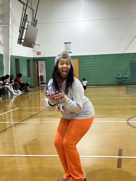A woman smiling and holding up an award.