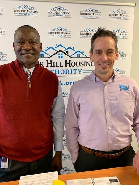 DewayneandJohn.jpg Executive Director Dewayne Alford and trainer John Emery in front of Rock Hill HA backdrop