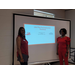 two ladies smiling in front of a projector with the words &quot;Jobs Plus Pre-employment Workshop&quot; on the screen