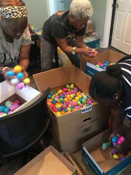 three women sorting easter eggs into boxes