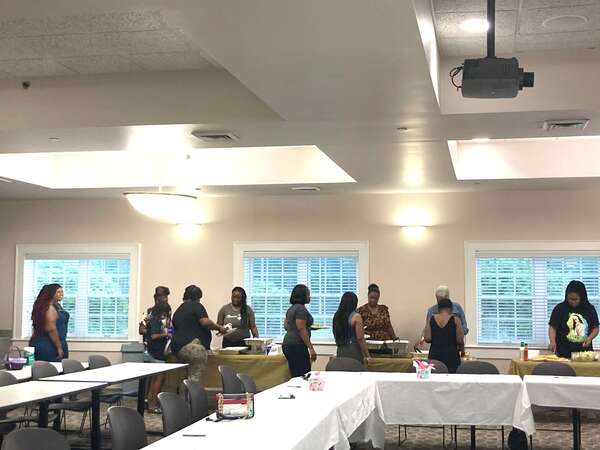 a wide view of ladies in a line being served food