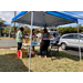 Volunteers help a resident who is looking through items on the table.