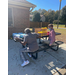 Two people are sitting at a picnic table that has Clorox wipes and face masks lined up. 