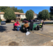 Two volunteer employees sit across from a resident that is filing out paperwork for her assessment.