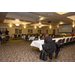 Four long tables are in the middle of the room; Christmas center pieces line the centers of the tables. 