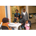 A man and a woman are with 5 children at the sign in table.