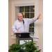 A gentleman stands behind the podium and raises one hand while he speaks into the microphone. 