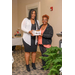 A woman with long dark hair passes a box to another woman. 