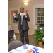 A tall gentleman in a suit addresses the room.