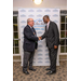 Two gentlemen shake hands with each other in front of a Rock Hill Housing Authority backdrop. 