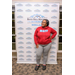 A woman puts on hand on her hip and smiles for the camera in front of the Rock Hill Housing Authority backdrop. 