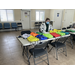 Woman sitting at a table full of backpacks.