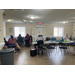 Wide angle view of room with people sitting doing paperwork.