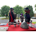 People talking to each other next to a table with a hard hat. 