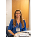  Woman smiling while sitting at a table.  