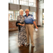  A man and woman, with their arm around each other, standing together and smiling.  