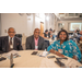  Two men and a woman are posing at a table smilling for a photograph.  