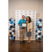  A man and a woman are standing with the gentleman holding a framed certificate.  