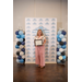  A woman smiles while holding a framed certificate in front of a Rock Hill Housing Authority backdrop and balloons on either side.  