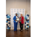  Two women are holding a framed certificate together while smiling.  
