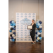  A woman posing with her framed certificate in front of a Rock Hill Housing Authority backdrop and balloons on either side of her. 