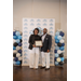  A man smiles while standing next to a smiling woman holding a framed certificate.  