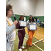  Two women hold awards and smile for a picture. 