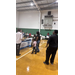  People standing and talking in the gym. 